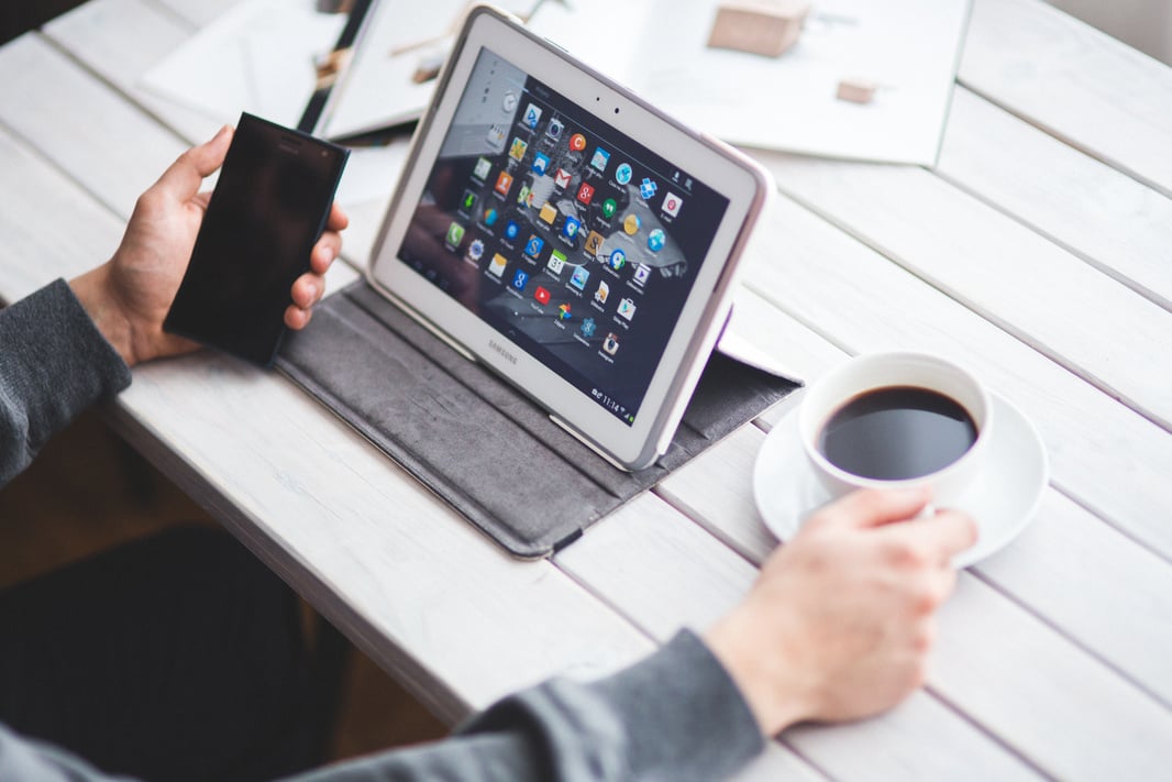 Man drinking coffee and using digital tablet