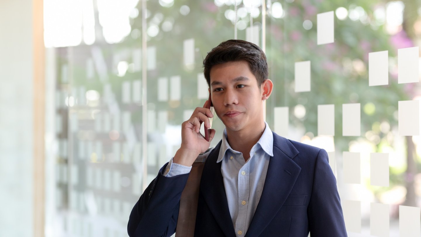 Man In Blue Suit Holding Smartphone